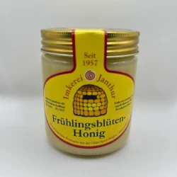 Glas Frühlingsblütenhonig vor weißem Hintergrund