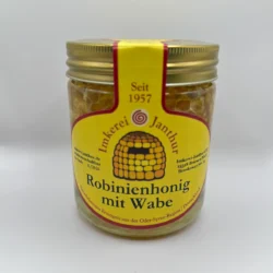 Glas Robinienhonig mit sichtbarem Wabenstück im Inneren