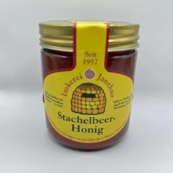 Glas Stachelbeerhonig vor weißem Hintergrund